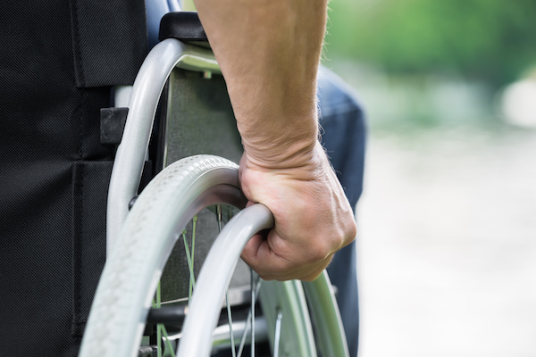 Disabled Man Pushing Wheel Of Wheelchair