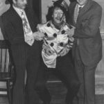 Flash Harry (Derek Dearne) And Alf Tubbe (Keith Beattie) Carry Jockey Fred Fipps (Bob Johnson) Back Into The Room.