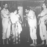 Convict Joseph Bolt (Geoff Hool) extracts a little on a account from reluctant Madame Parole (Phyllis Cowin), assisted by Alfred and Jules