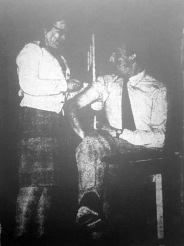 Dr. Wooley (Audrey Chandler) vaccinates Clive Rodingham (R. Yowart)