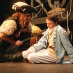 Long John Silver (David Aitken) with a defeated Captain Smollett (Katie Sharrock-Fearon)